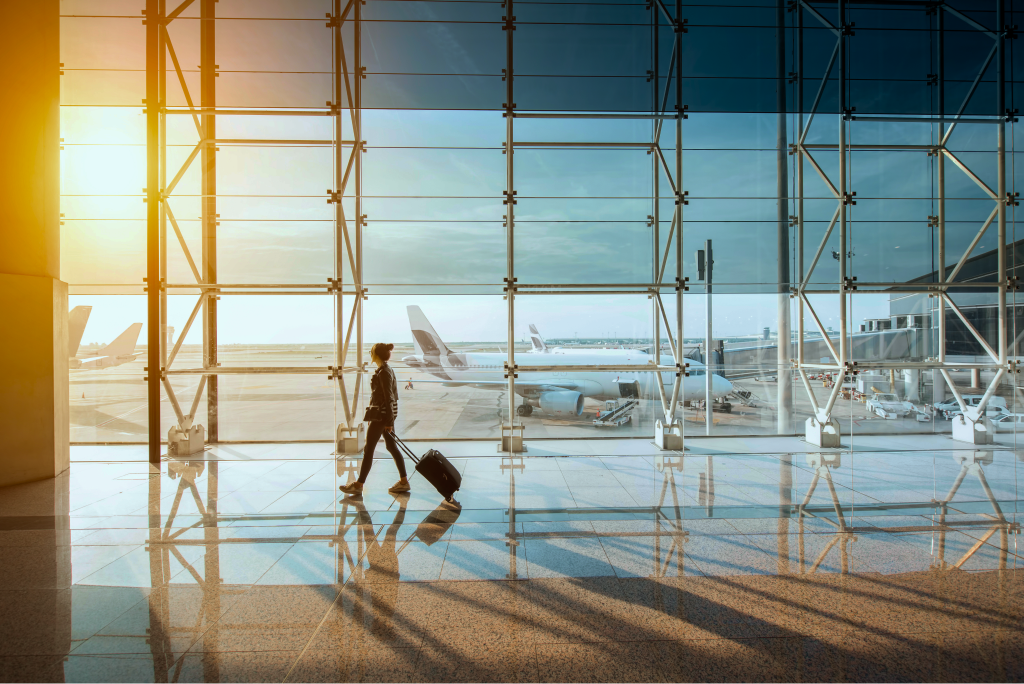 Traveler at an airport window at sunset